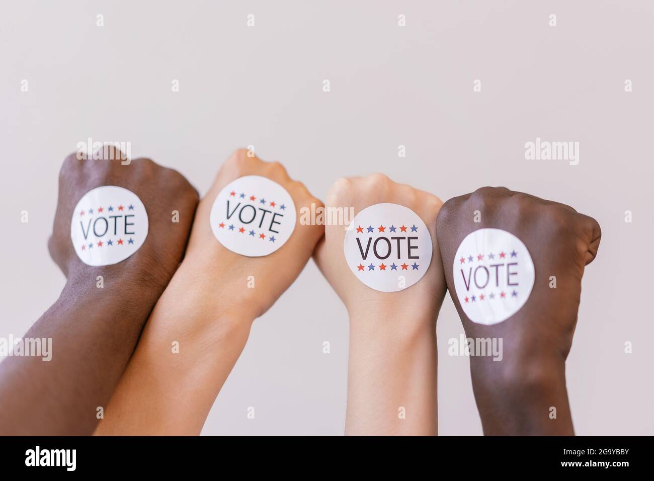 Close up photo of vote stickers on people s first in white background