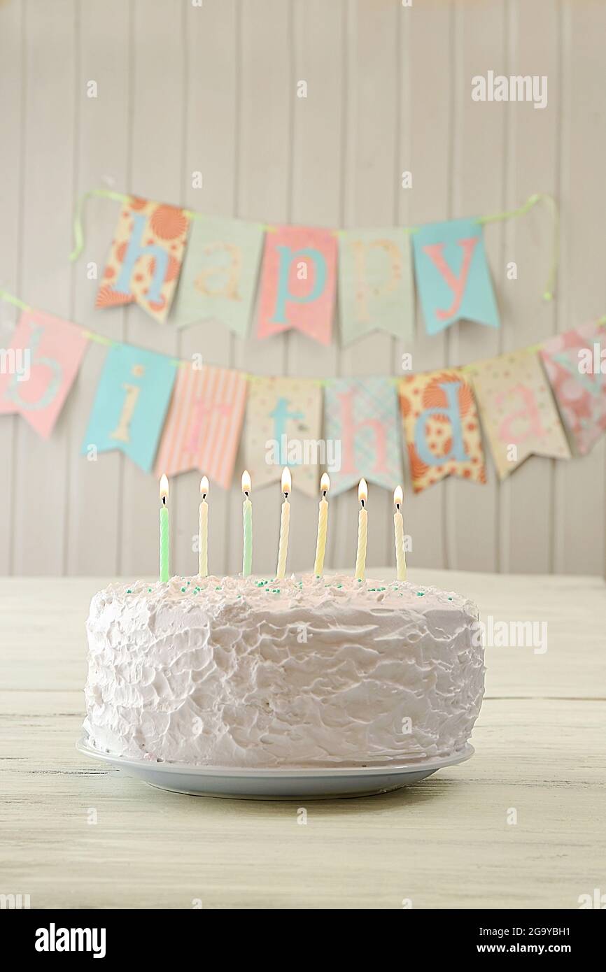 Birthday cake with candles on decorated wall background Stock Photo - Alamy