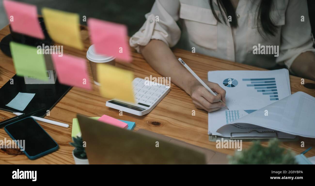 Close up business or accountant woman working in finance and accounting Analyze financial budget in the office. Business Calculation Concept Stock Photo