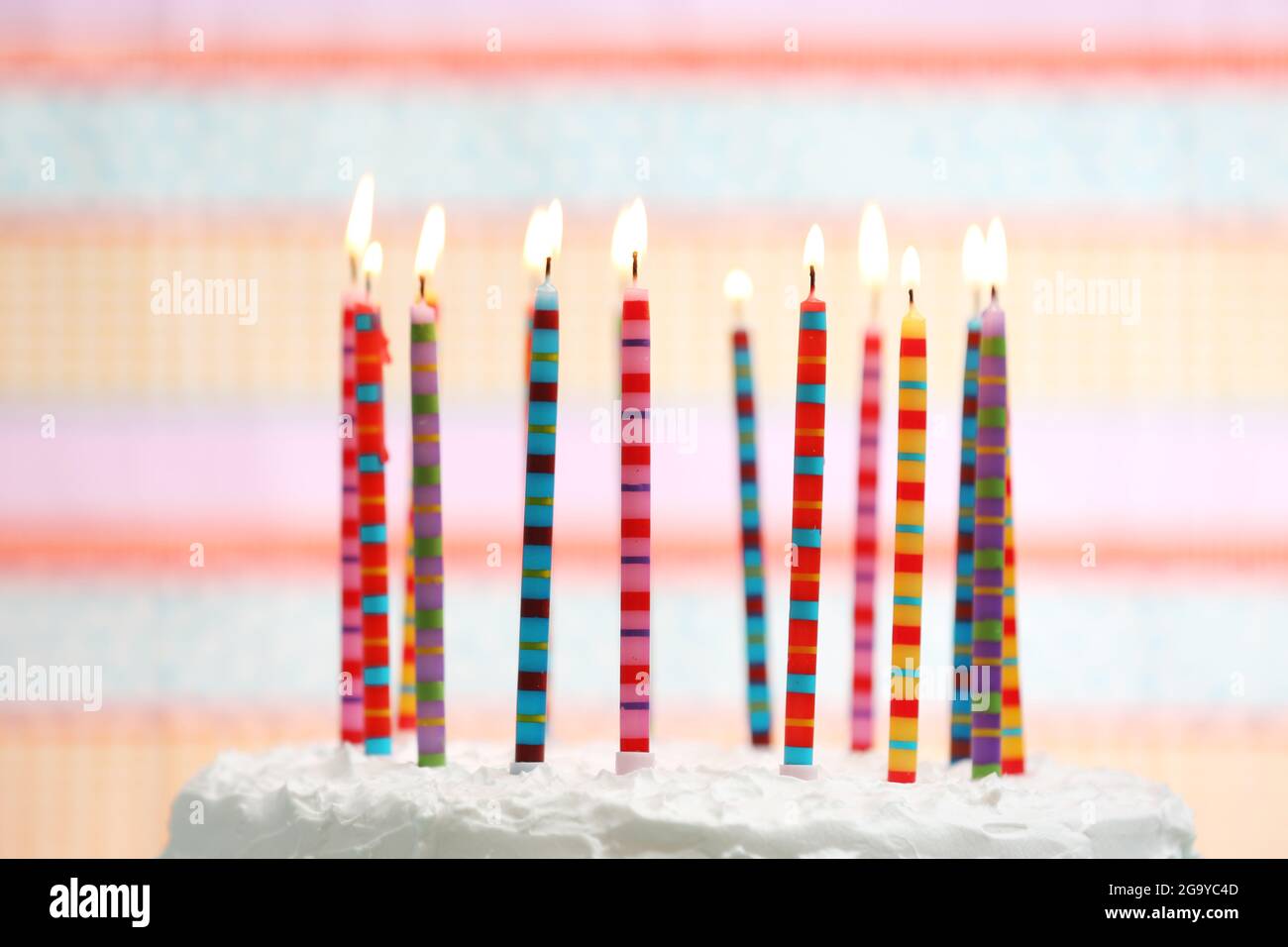 Birthday cake with candles on colorful striped background Stock Photo ...