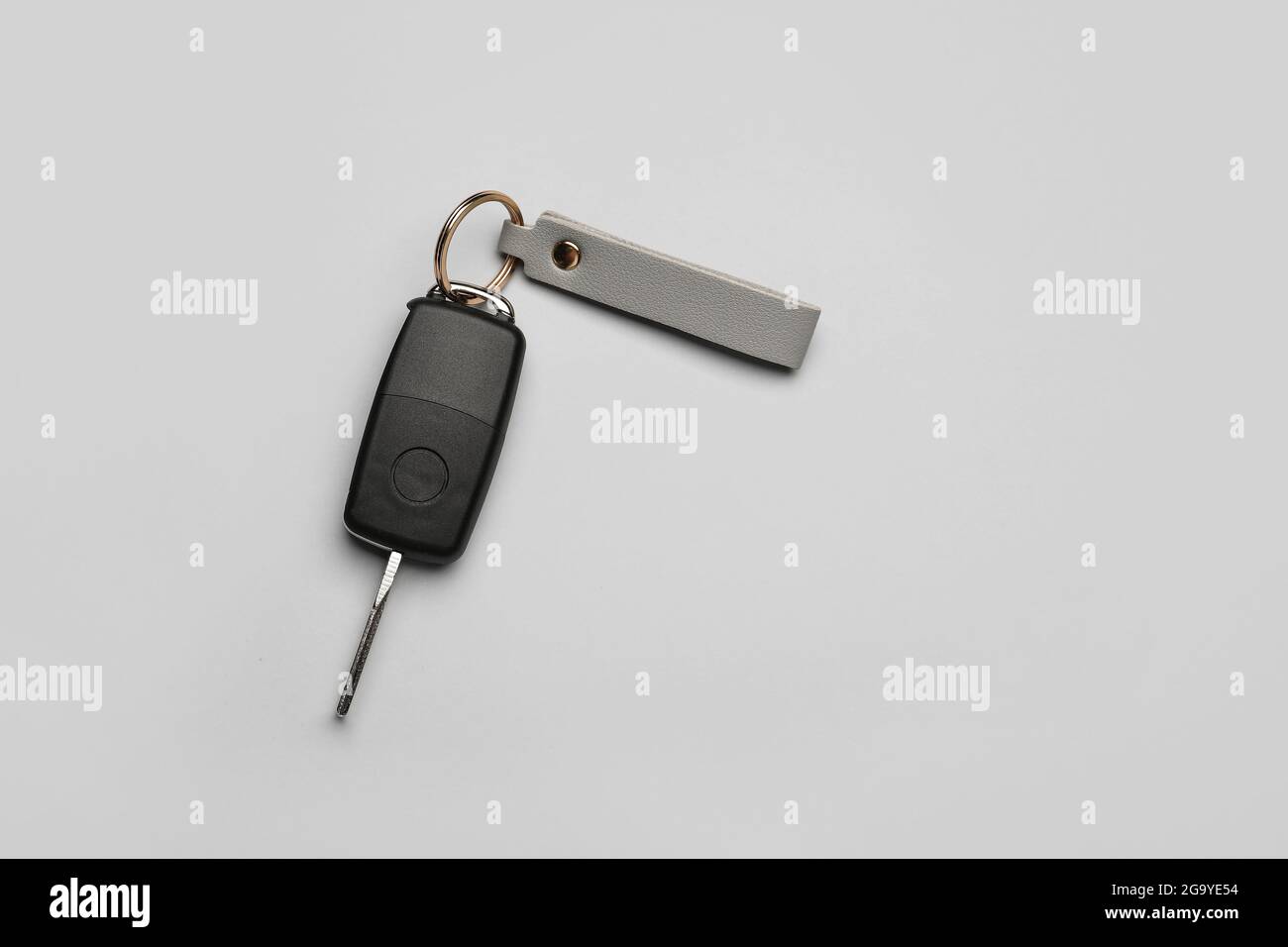 Car key with leather keychain on grey background Stock Photo