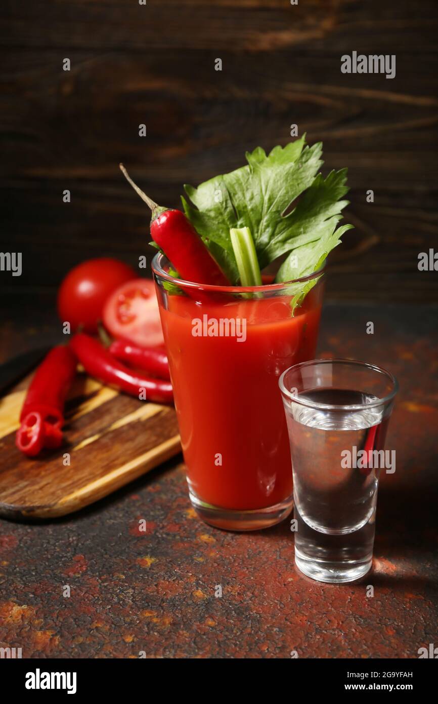 Glass of bloody mary cocktail garnished with cilantro, red chili pepper