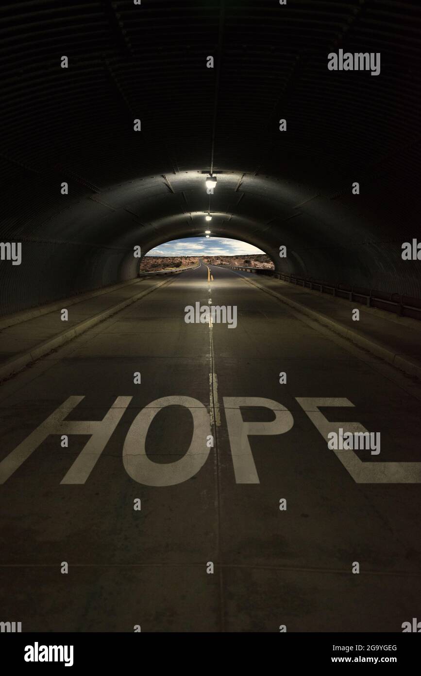 Word hope written on a road with light at the end of a tunnel, USA Stock Photo