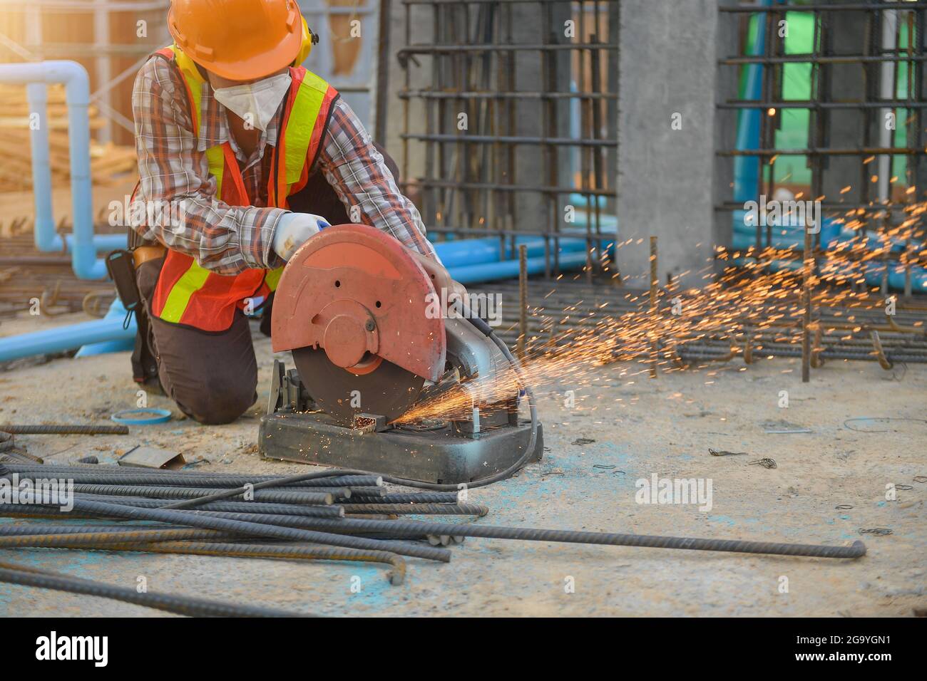 Construction worker using a circular saw on a building site, Thailand Stock Photo