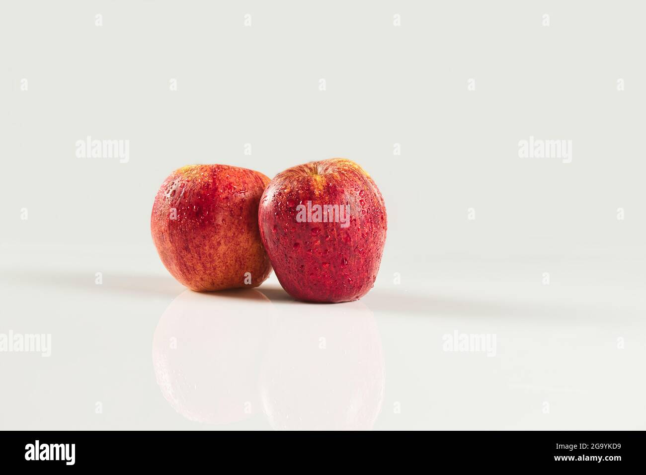 foreground of two red apples with drops on white background Stock Photo