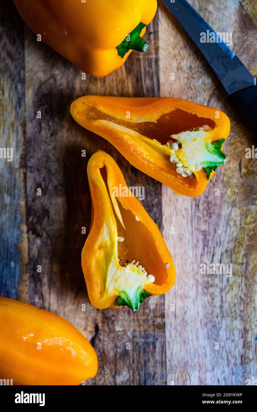 Yellow bell peppers on a chopping board Stock Photo - Alamy