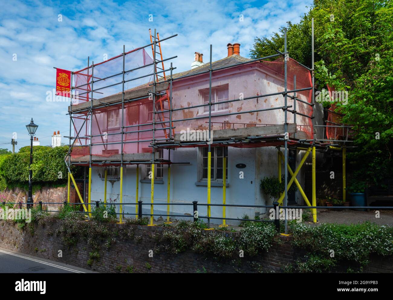 2 storey house in the UK covered in scaffolding while maintenance work is carried out. Stock Photo