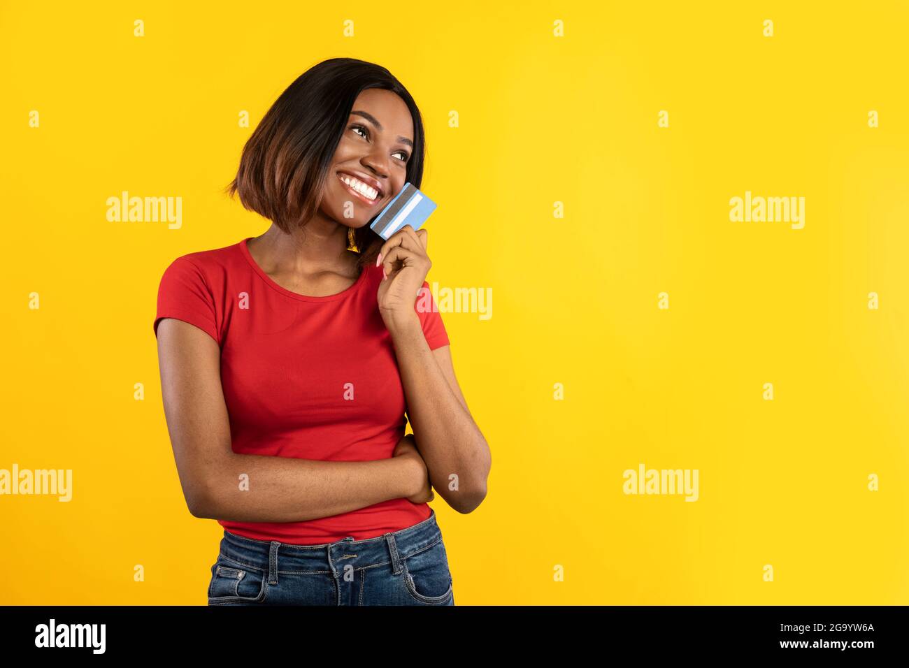 African Female Posing With Credit Card Dreaming About Shopping, Studio Stock Photo
