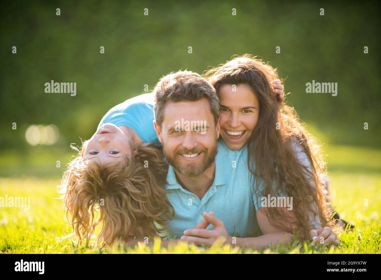 happy family of mother daddy and son kid relax in summer park green grass, family Stock Photo
