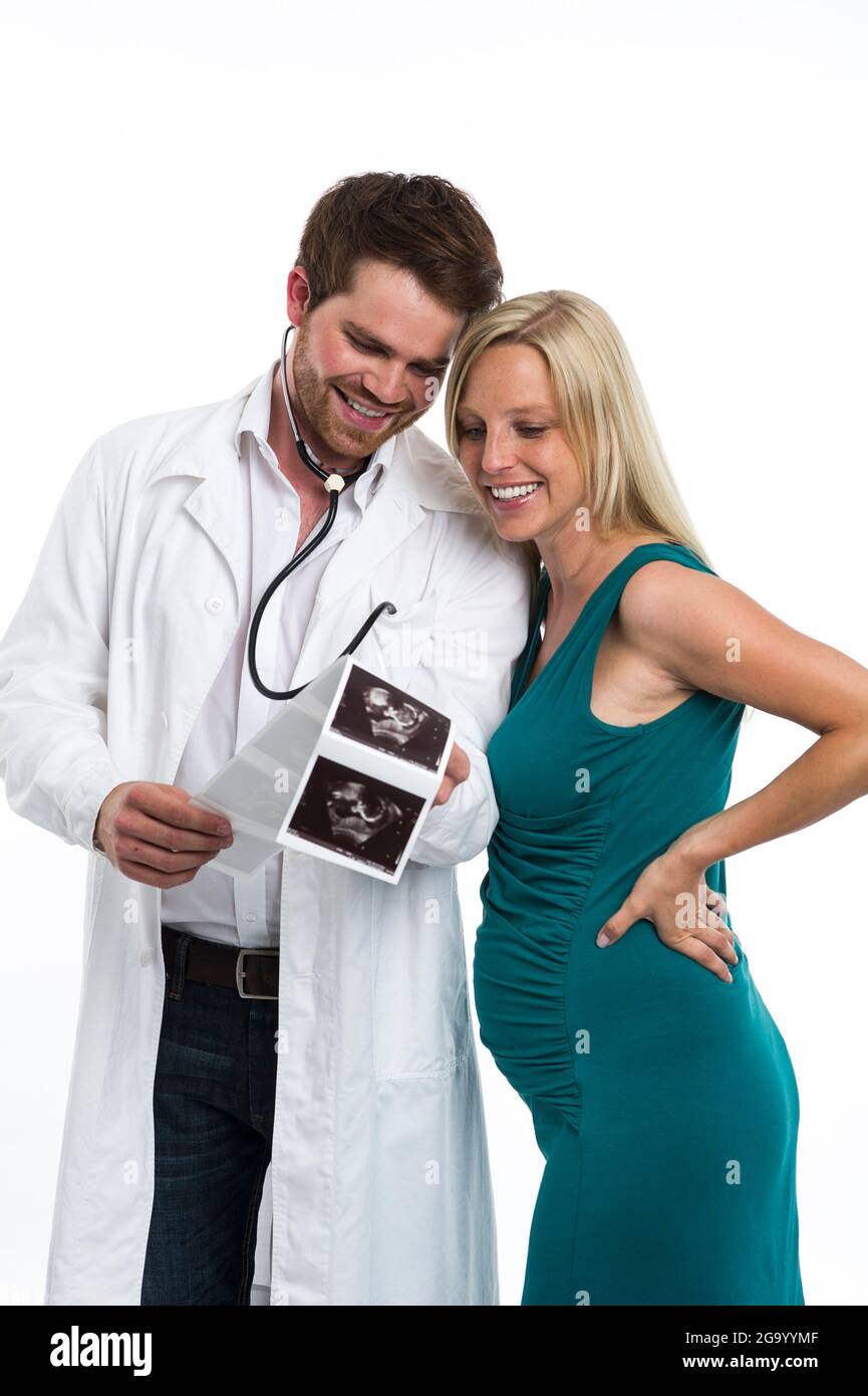 gynecologist happily looking at the ultrasound images of the unborn baby with a pregnant woman  , Germany Stock Photo