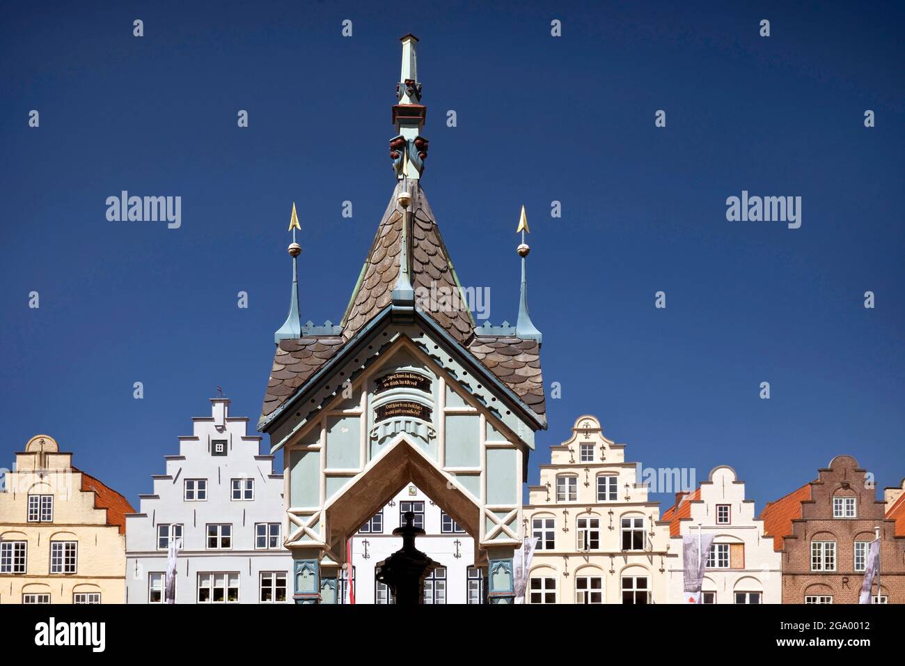 historic well house at the market place in front of gabled houses, Germany, Schleswig-Holstein, Northern Frisia, Friedrichstadt Stock Photo