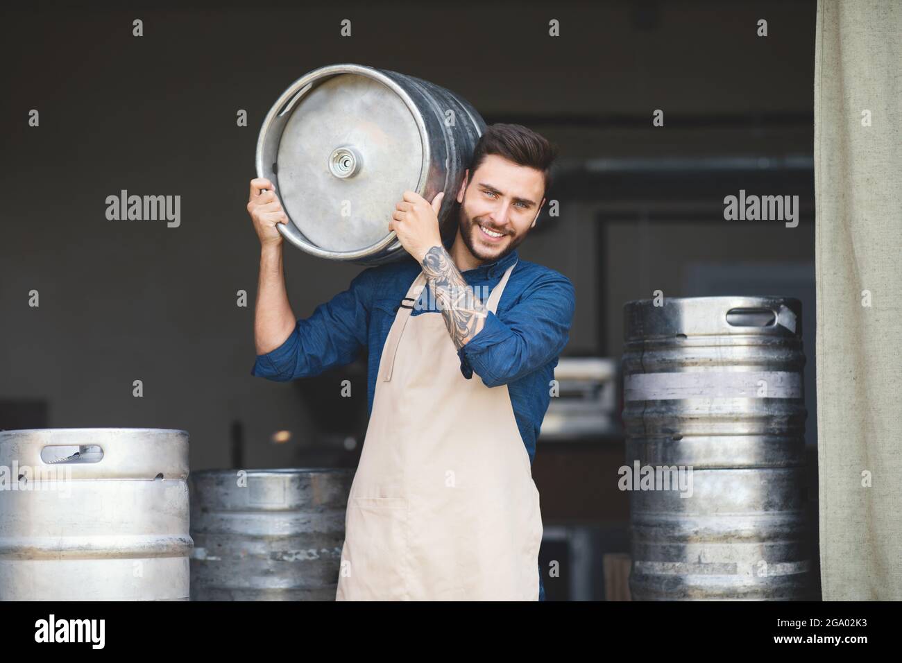 Strong warehouse worker, brewery owner working at plant, small business and success emotions Stock Photo