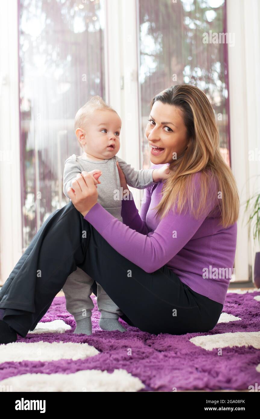 Happy mother sitting on the floor and playing with her baby boy Stock ...