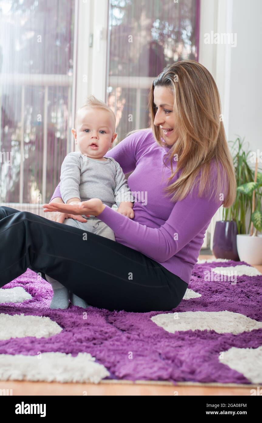 Happy mother sitting on the floor and playing with her baby boy Stock ...