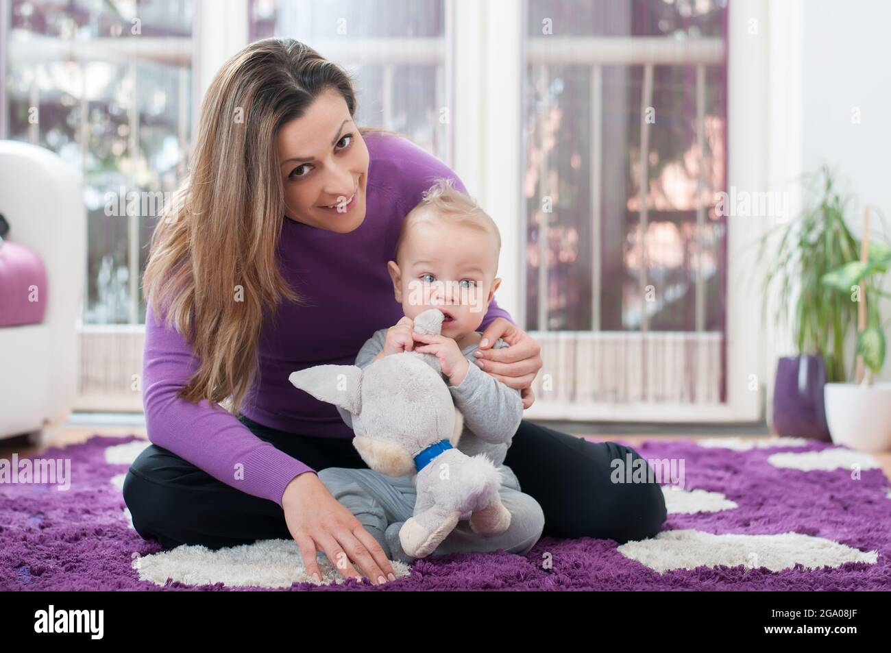 Happy mother sitting on the floor and playing with her baby boy Stock ...