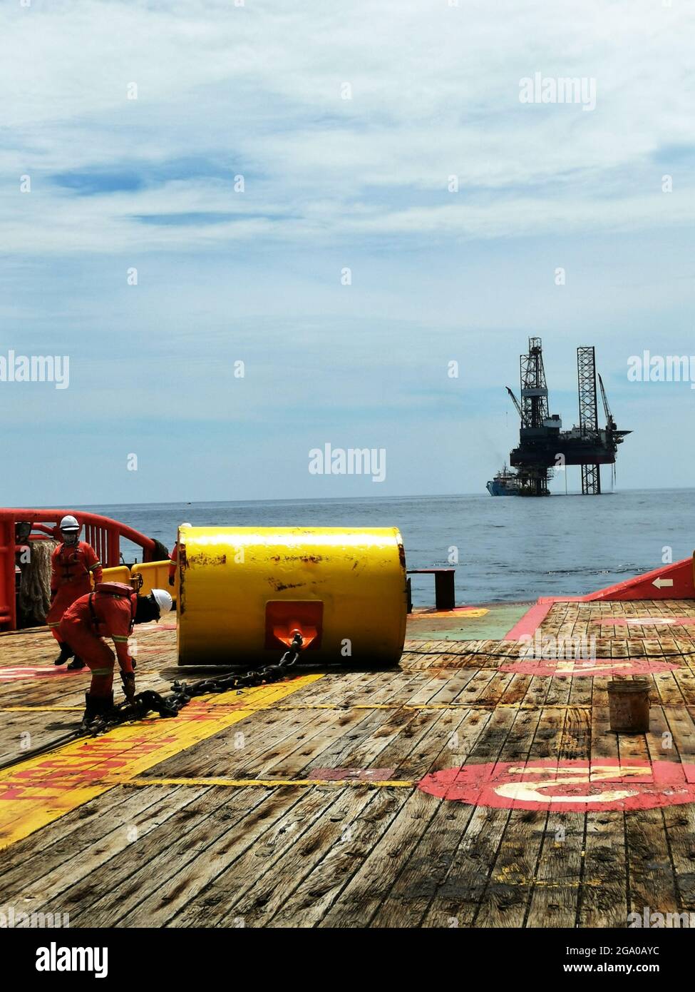 Marine crew working on deck during anchor handling operation near hi