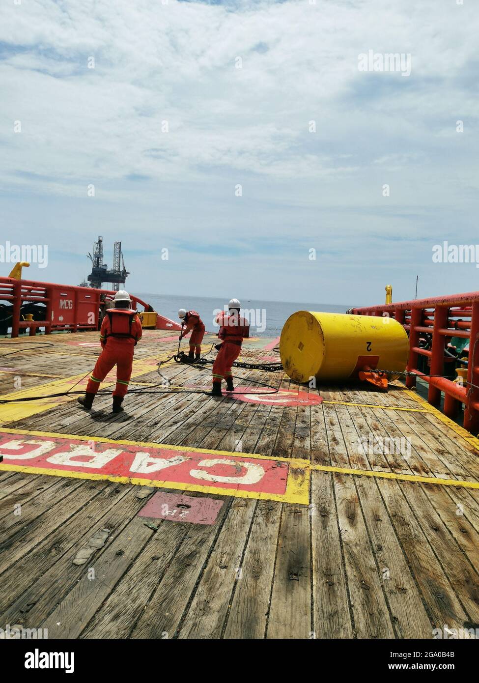 Marine crew working on deck during anchor handling operation near hi