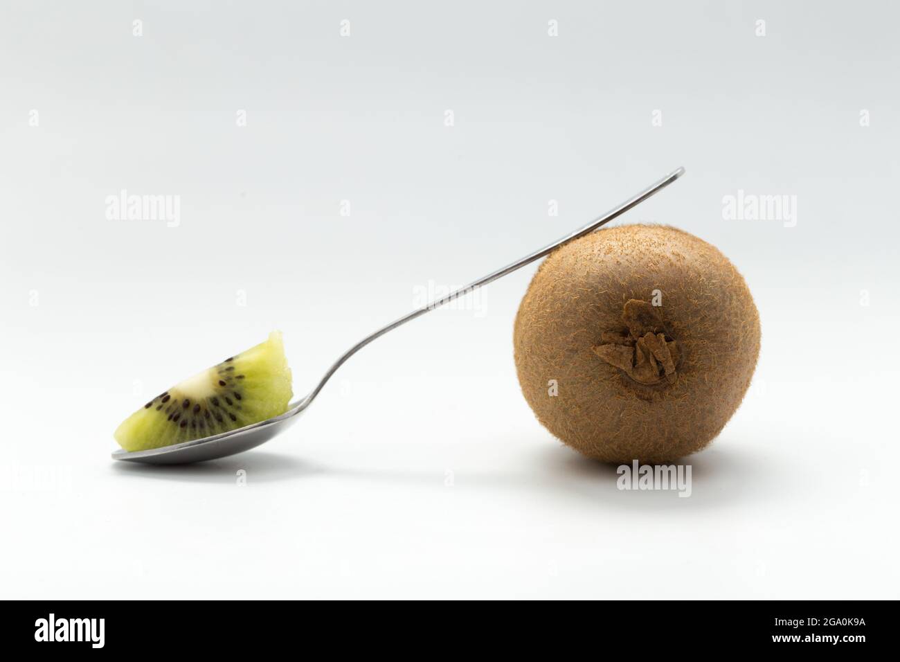 kiwi and spoon on white background Stock Photo - Alamy