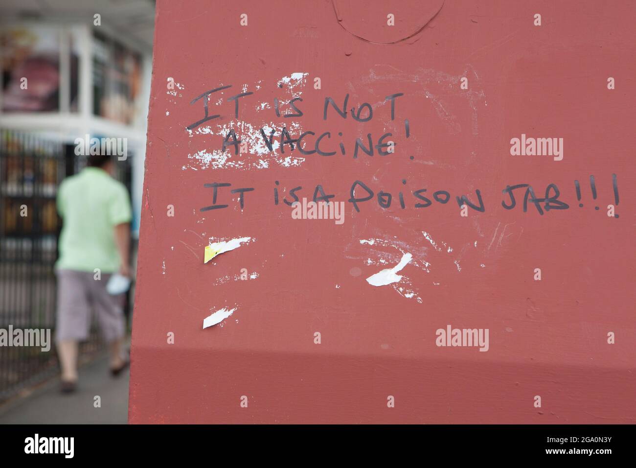 London, UK, 28 July 2021: Anti vaccine graffiti on a recycling bank in Brixton, London. An anti-vaxxer has written 'It is not a vaccine! It is a poison jab!!!' in black pen. Anna Watson/Alamy Live News Stock Photo