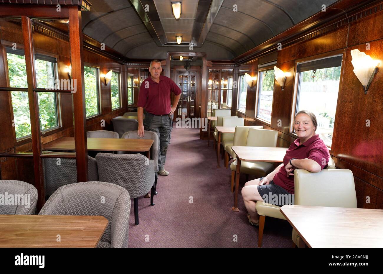 Simon and Diana Parums inside their full size steam train with carriages, tracks and platform as they converted and restored Bassenthwaite Lake station in Keswick, offering a dining experience on a Hollywood movie restaurant carriage as its centrepiece, when they open it to the public as an attraction. Picture date: Wednesday July 28, 2021. Stock Photo