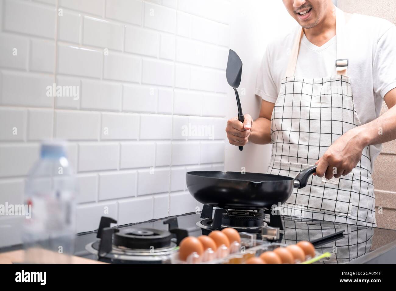 Asian chef fried eggs on pan to thai food in kitchen on gas stove The oil in pan boiling.Eggs and pork cooked. before serving to happy family to eat t Stock Photo