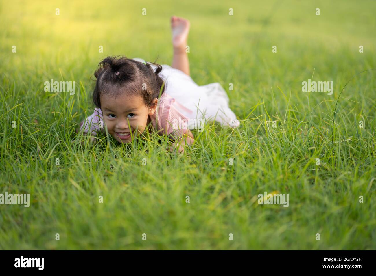 Cute Asian female child playing in the grass Stock Photo - Alamy