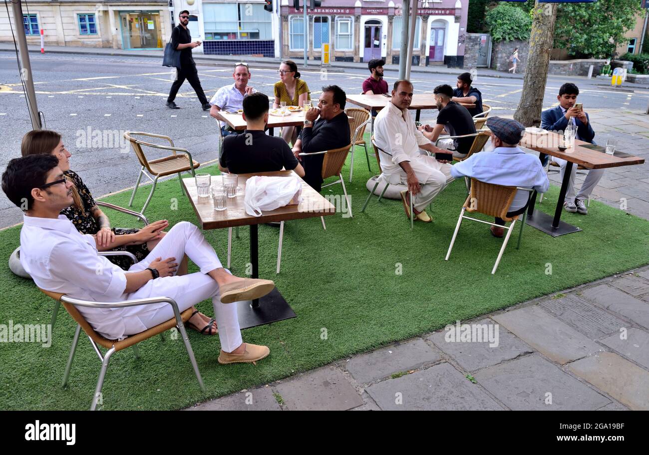 Tables and chairs with customers of restaurant, bar, pub out on pavement for food and drinks, Bristol, UK Stock Photo