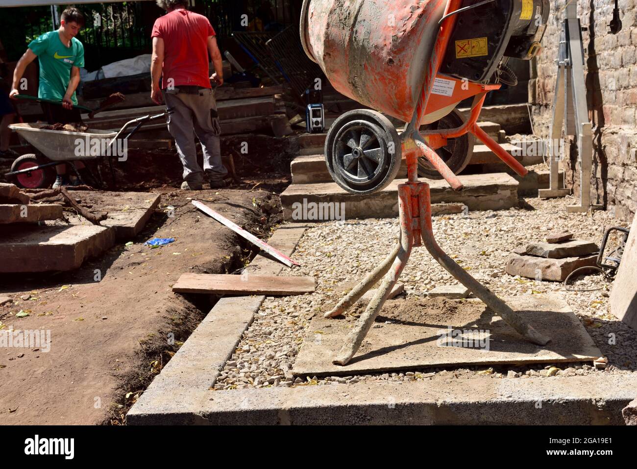 Small building site with cement mixer and workman Stock Photo