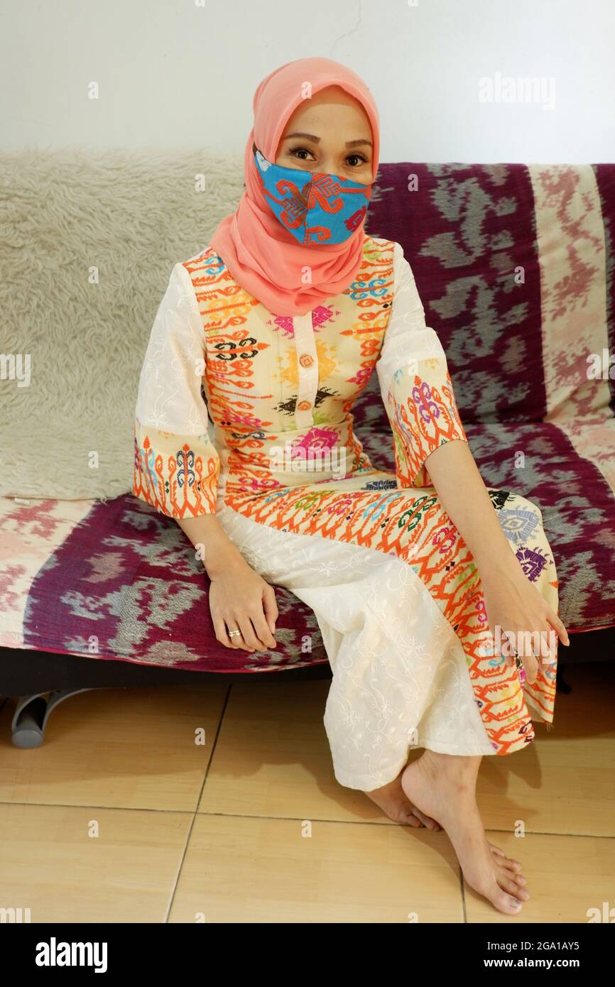 A muslim woman wears a colorful facemask Stock Photo - Alamy