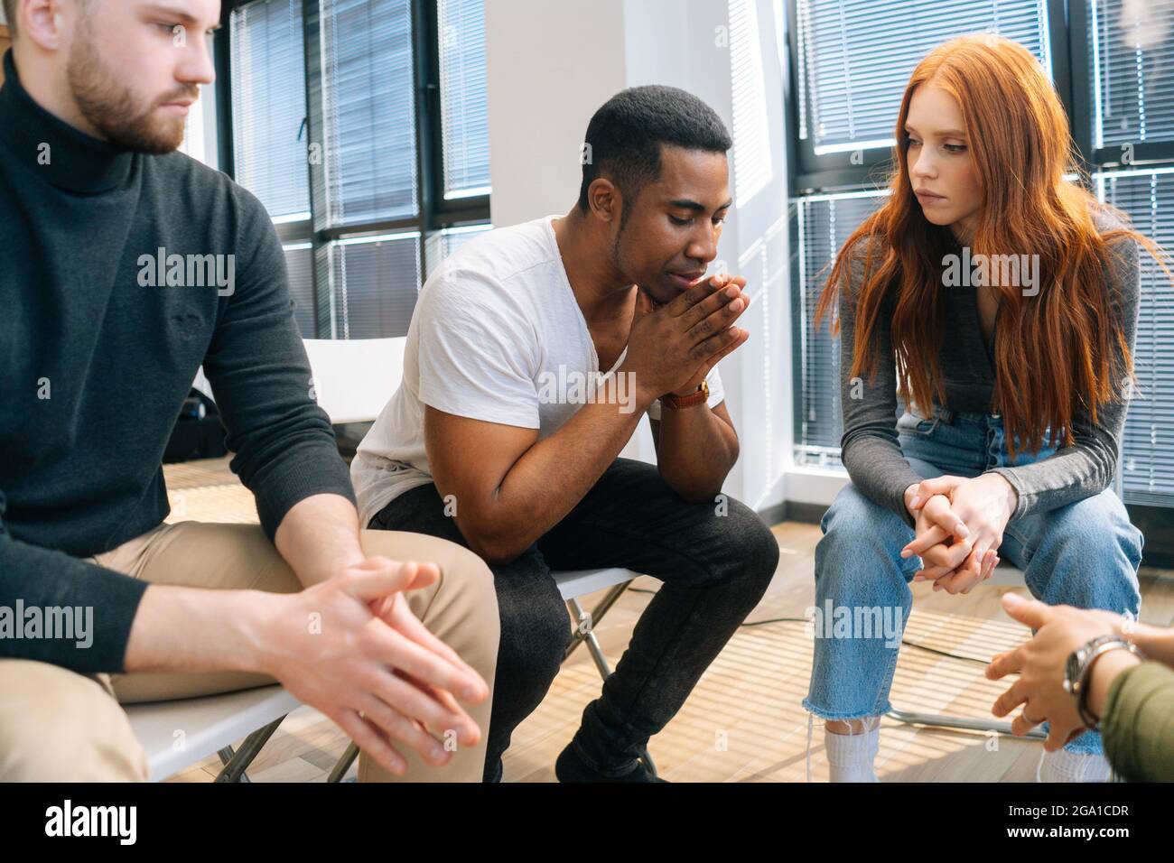 Closeup of depressed African American young man sharing problem