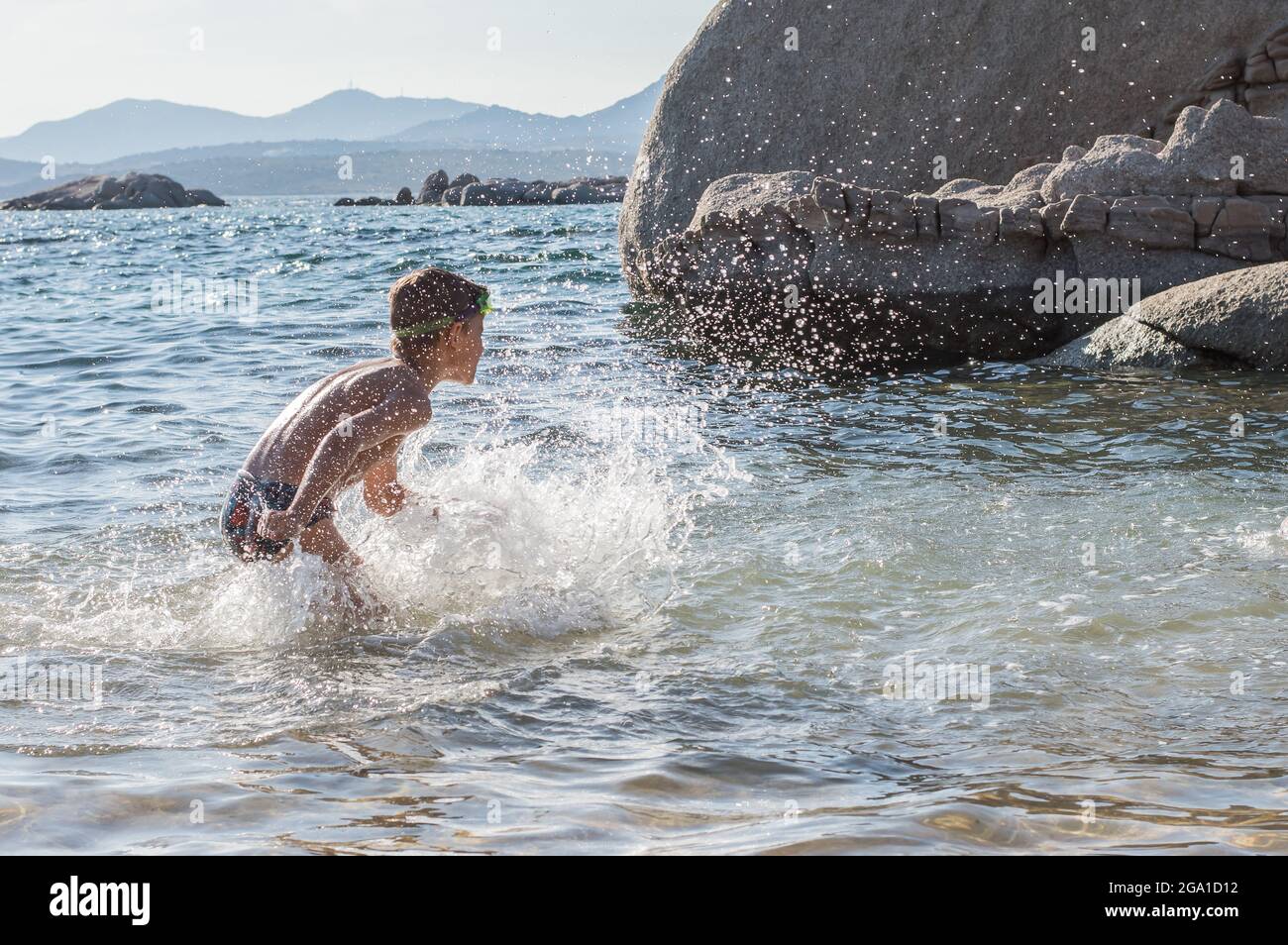 happy boy is playing splashes in the water on the beach Stock Photo - Alamy