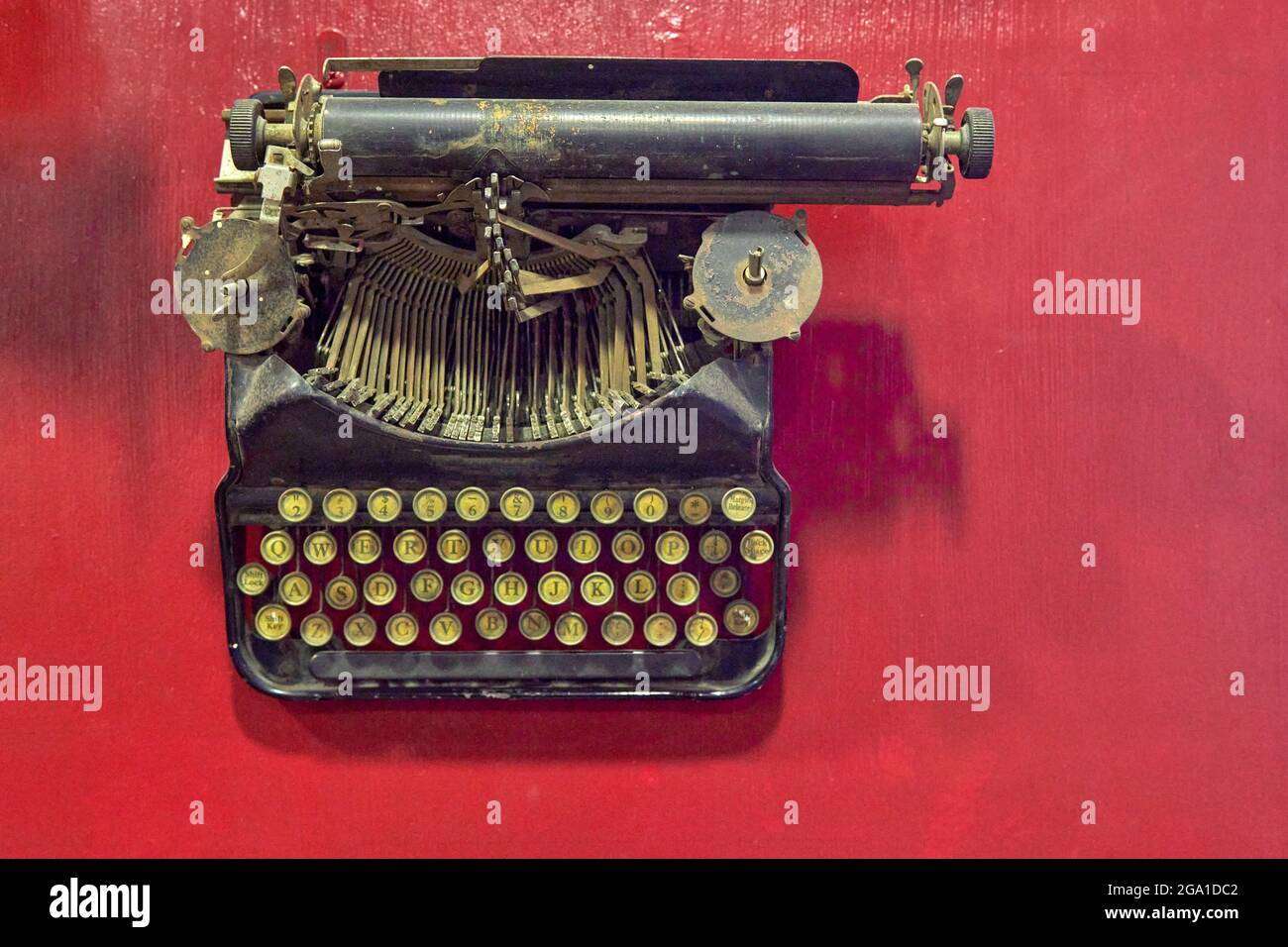 old aged black typewriter, top view and red background. horizontal and