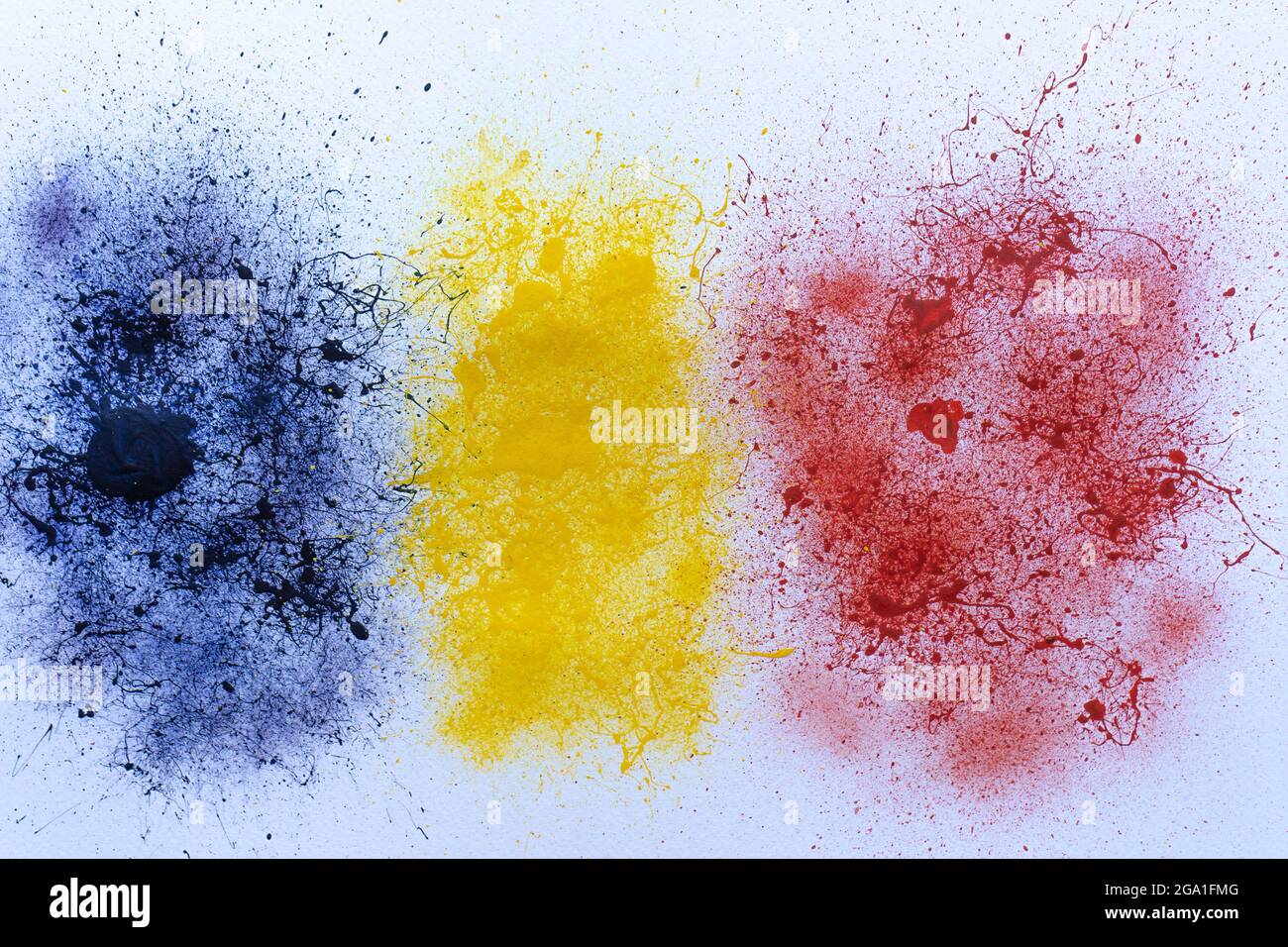 Messy blue, yellow, and red paint scattered on a white surface with ...