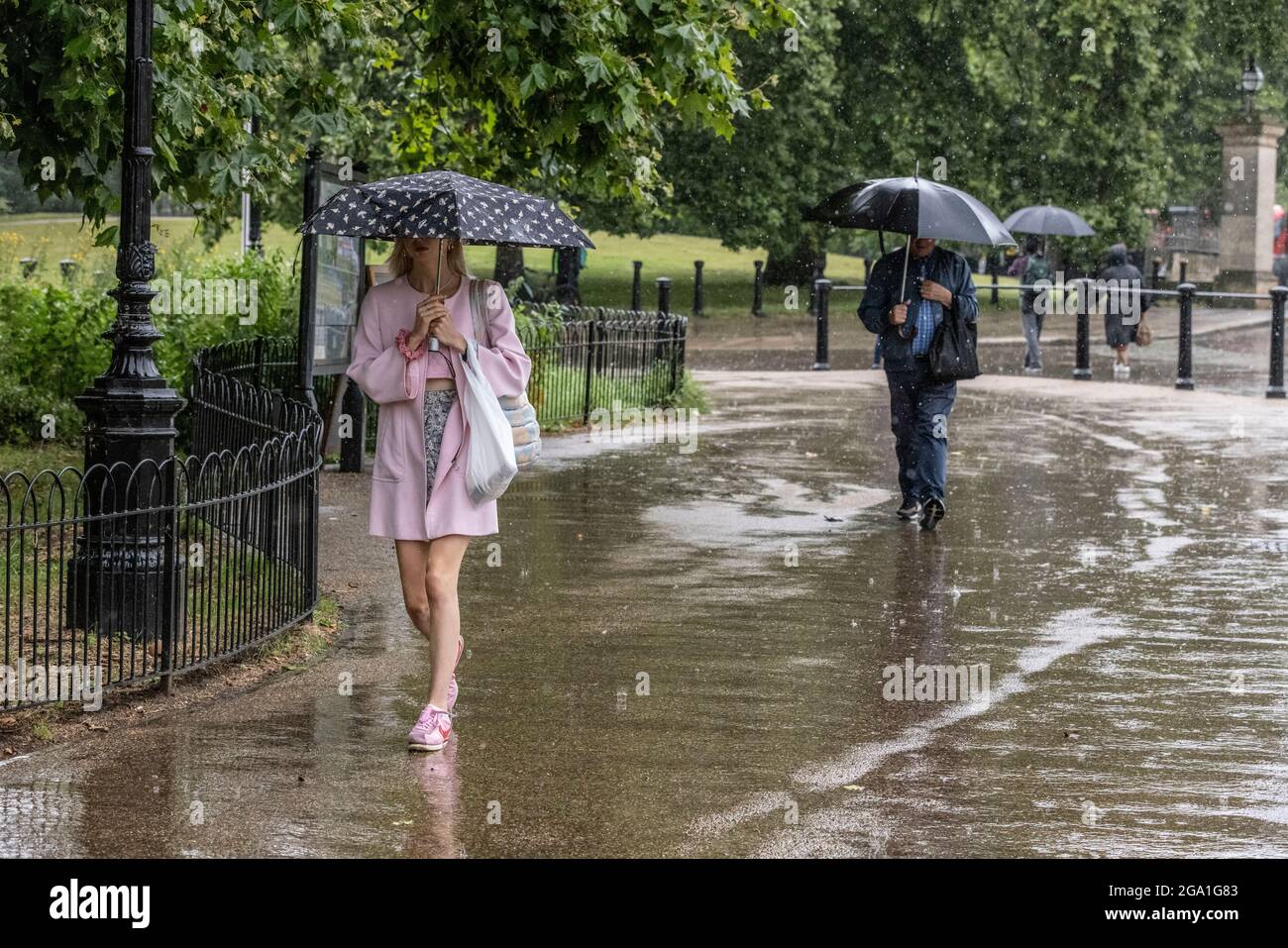 London, UK. July 28 2021: Heavy Rain Showers hit Knightsbridge, Central London, England, UK Picture shows touristswalking through Hyde Park Corner in the rain as heavy rain showers sweep across Central London and southern parts of England. Credit: Clickpics/Alamy Live News Stock Photo