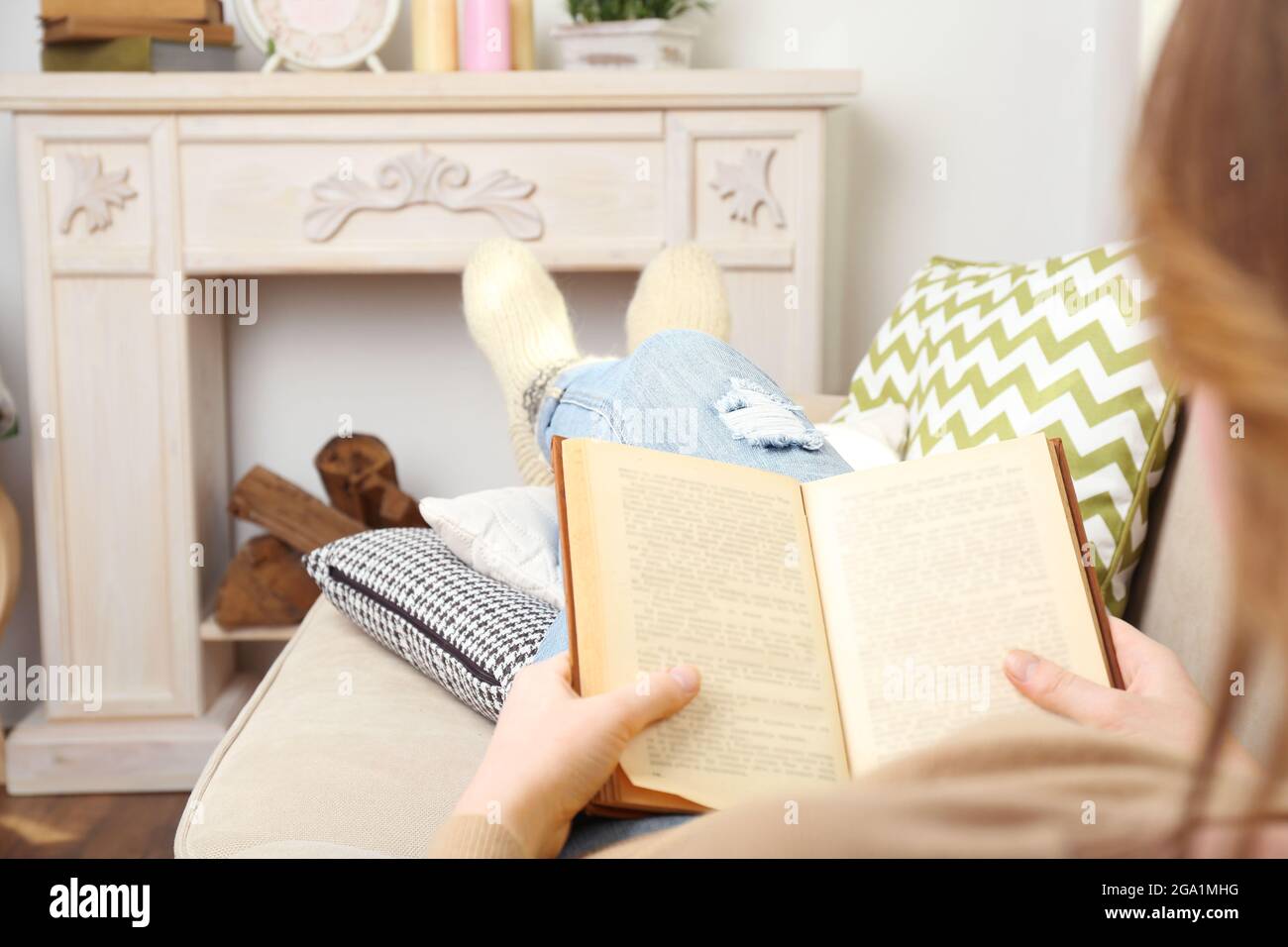 Woman reading book on sofa in room Stock Photo Alamy