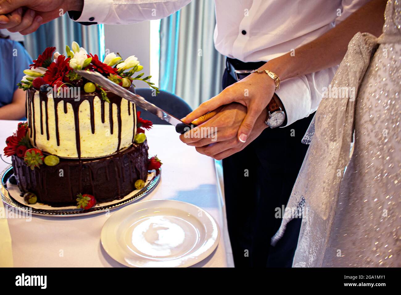 Newlyweds cut the wedding cake. The bride and groom at the wedding cut