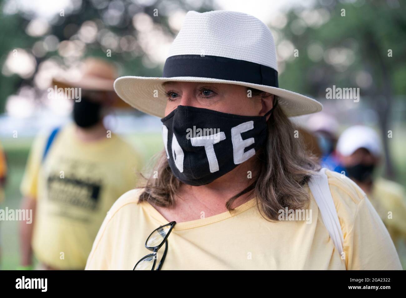 Georgetown, United States. 28th July, 2021. National and Texas voting rights activists, including this woman in a 'Vote' mask, begin a 30-mile, four-day march from Georgetown, Texas to the State Capitol in Austin. Due to summer Texas heat, several 100-person shifts will trade off marching about 4 miles each. The March for Democracy urges passage of the John Lewis Voting Rights Act and elimination of statewide barriers to voting. Credit: Bob Daemmrich/Alamy Live News Stock Photo