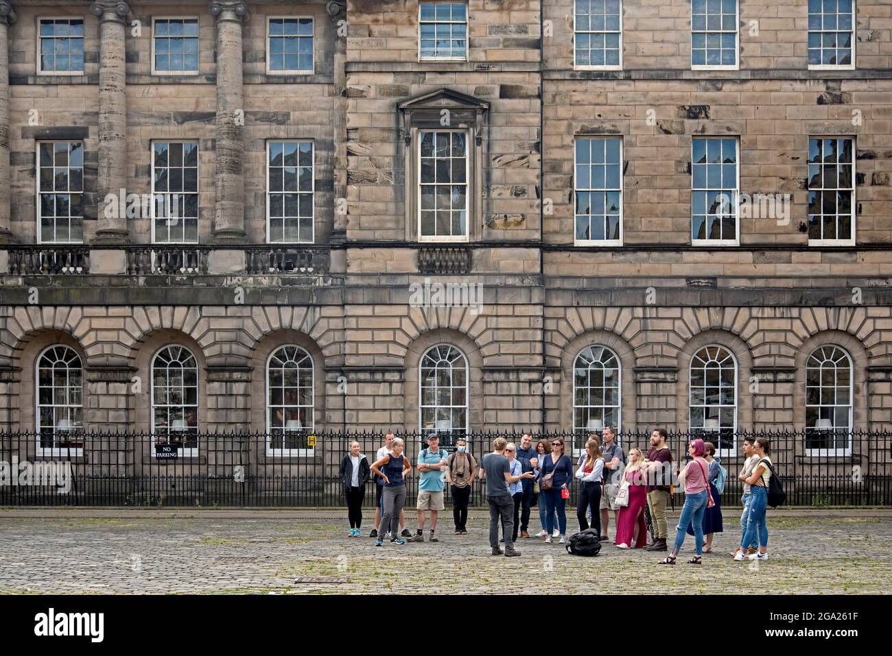 Group of tourists on a walking tour gather in Parliament Square in Edinburgh's Old Town. Stock Photo