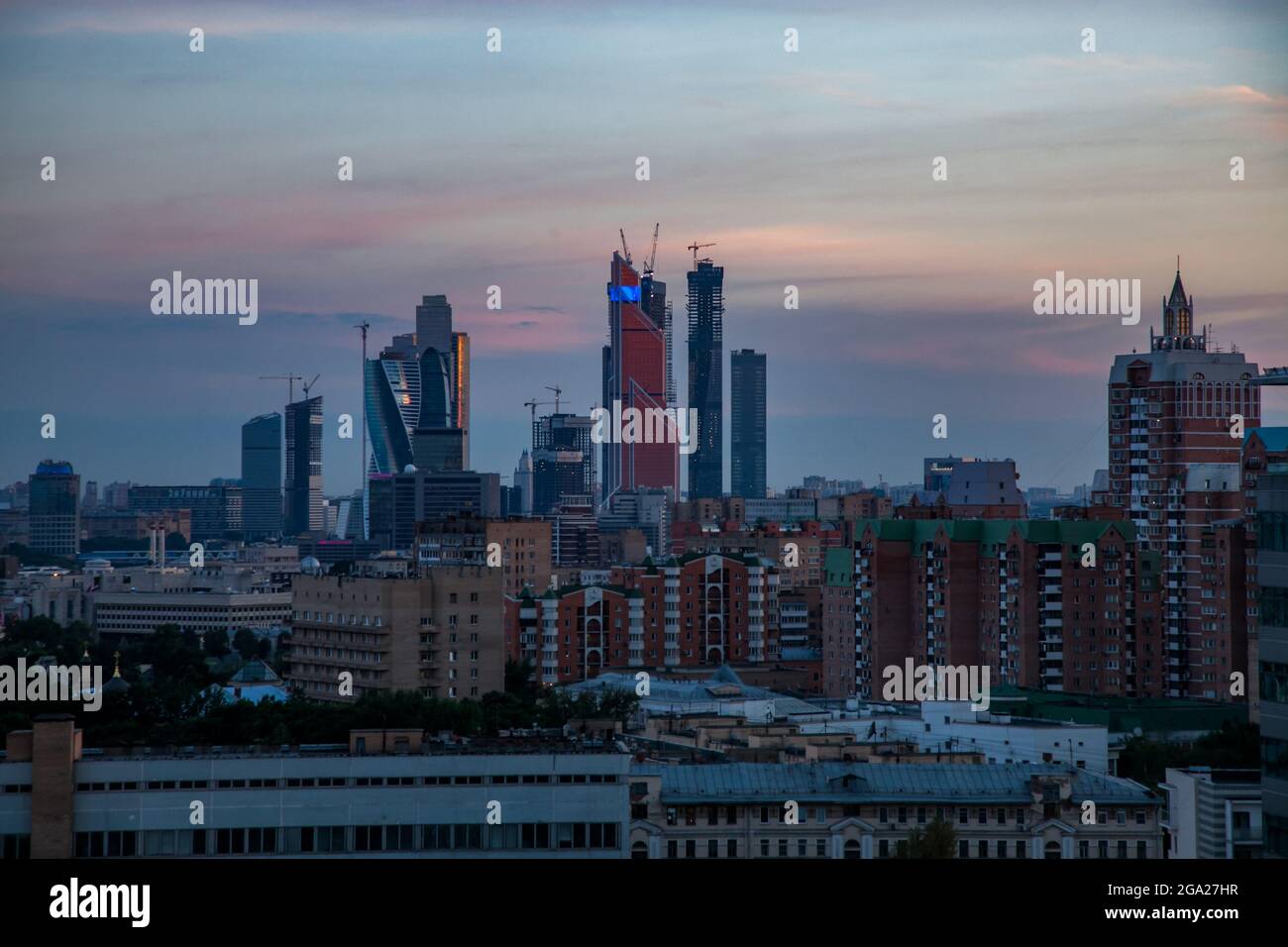 Dusk view on Moscow City in construction on colored blue and red cloudy sky. Evening after sunset panoramic photo. Stock Photo
