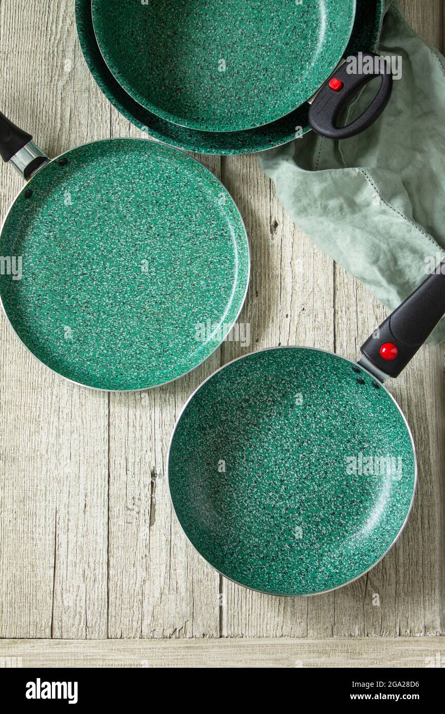 New Set Empty fry pan green with ceramic coatingon on a rustic kitchen