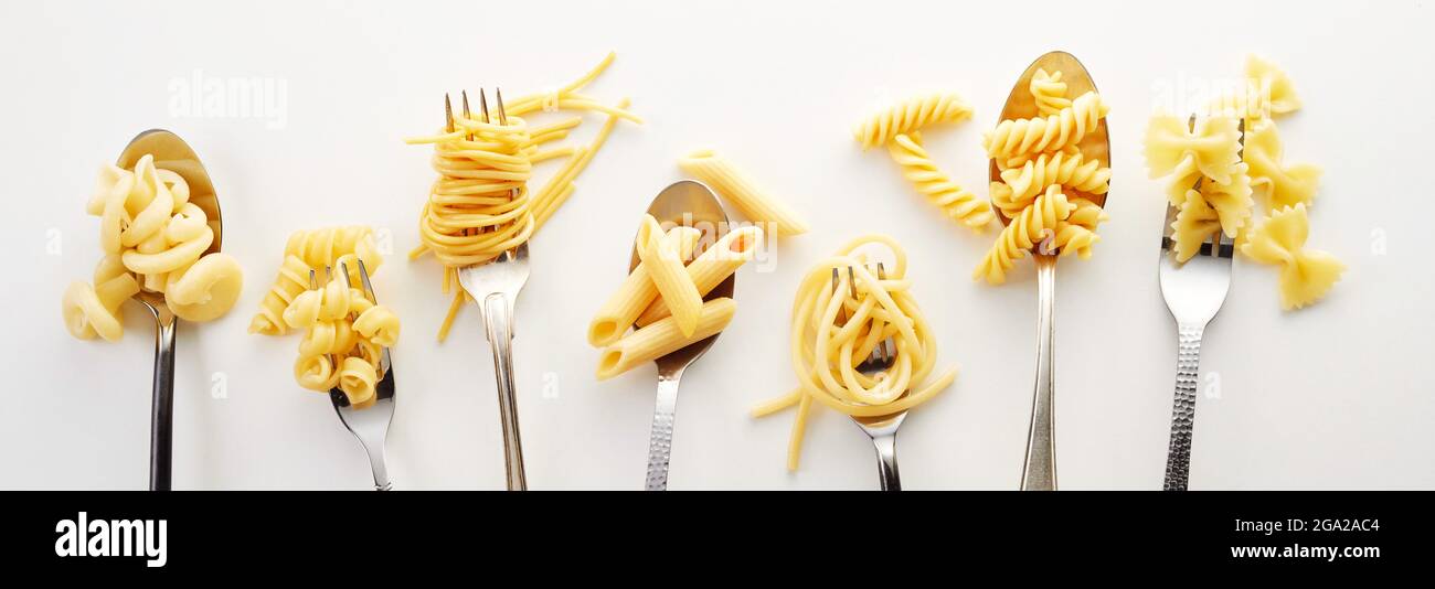 Types of spaghetti, noodles, and pasta on the forks and spoons in the white background Stock