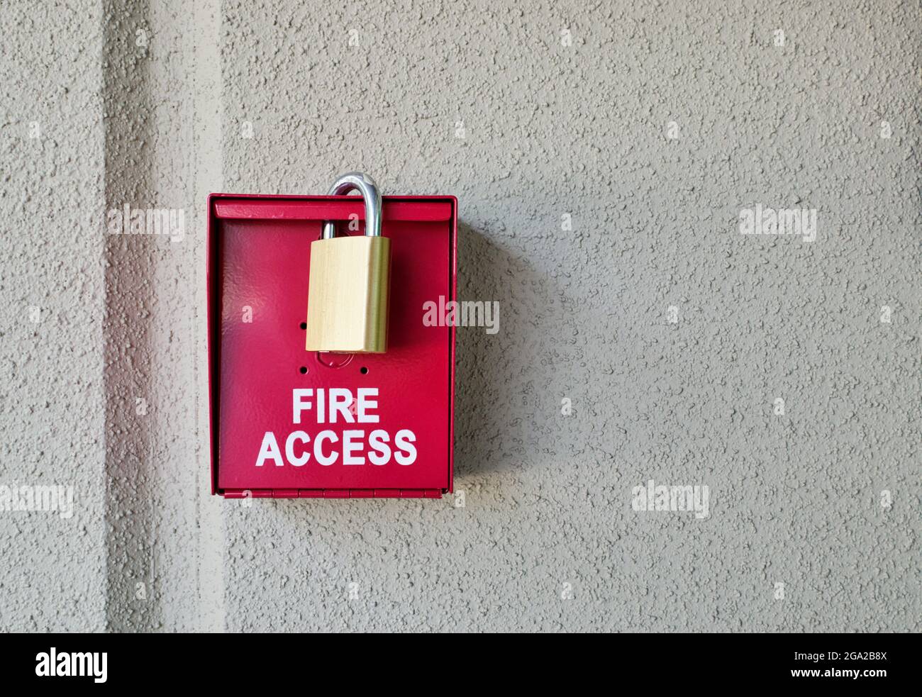 Red fire access box with padlock on a plain textured wall with copy space Stock Photo Alamy