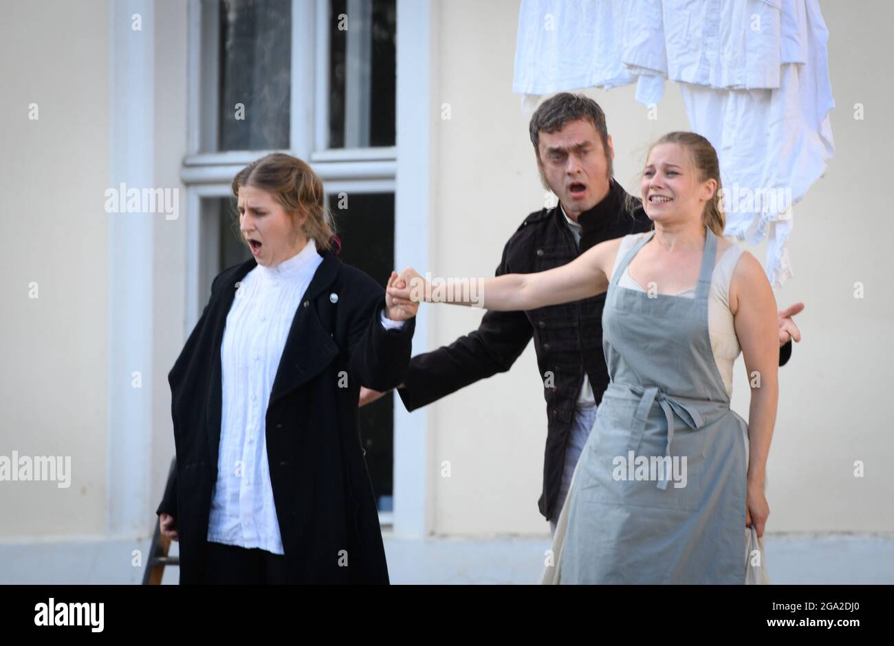 Rheinsberg, Germany. 28th July, 2021. The singers Larissa Angelini (l) as Leonore (Fidelio) and Daniela Ruth Stoll (r) as Marzelline and singer Bartosz Szulc (M) as Rocco sing during the media rehearsal 'Fidelio oder die eheliche Liebe' (Ludwig van Beethoven) in a production by Georg Quander at the Kammeroper Schloß Rheinsberg. Premiere of the opera in three acts is on 04.08.2021, 19.30 clock. Credit: Soeren Stache/dpa-Zentralbild/dpa/Alamy Live News Stock Photo