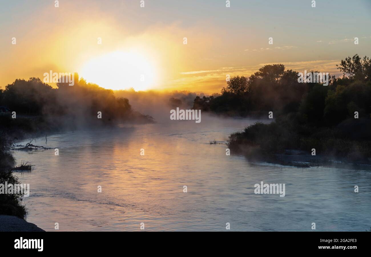 Mist rising off the North Platte River with a glowing sun on the horizon at sunrise; Nebraska, United States of America Stock Photo