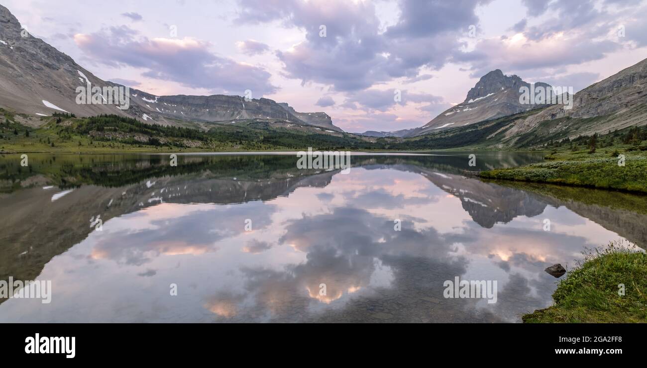 Rocky Mountains reflected in a tranquil Baker Lake at sunset in Banff National Park; Alberta, Canada Stock Photo