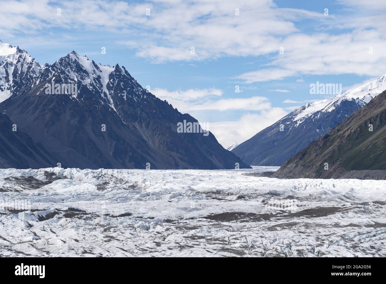 Massive glacial flow ice of the Donjek Glacier through the snowcapped mountain peaks; Kluane National Park and Reserve, Yukon, Canada Stock Photo