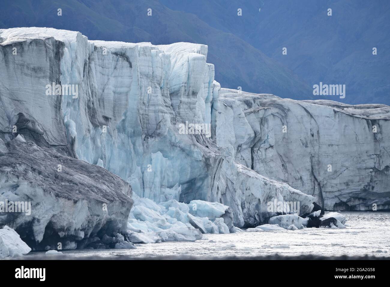 Close-up of the Donjek Glacier with recently-calved pieces of ice frozen against the edge of the glacier Stock Photo