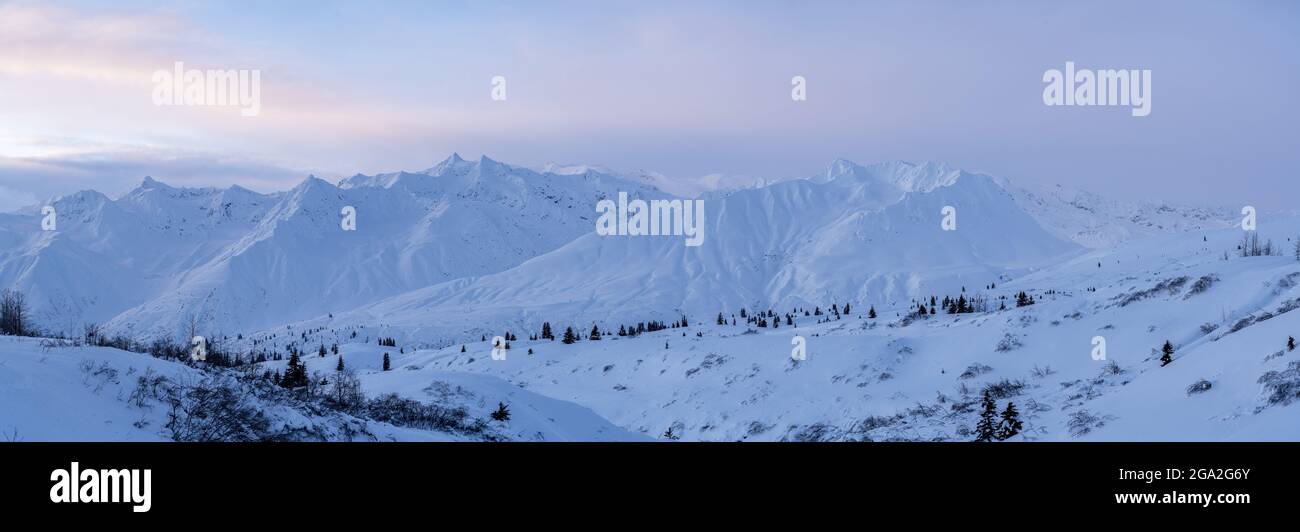 Impressive snow covered mountain ridge along the Haines Highway in the soft, early morning light near Haines Junction; Yukon, Canada Stock Photo