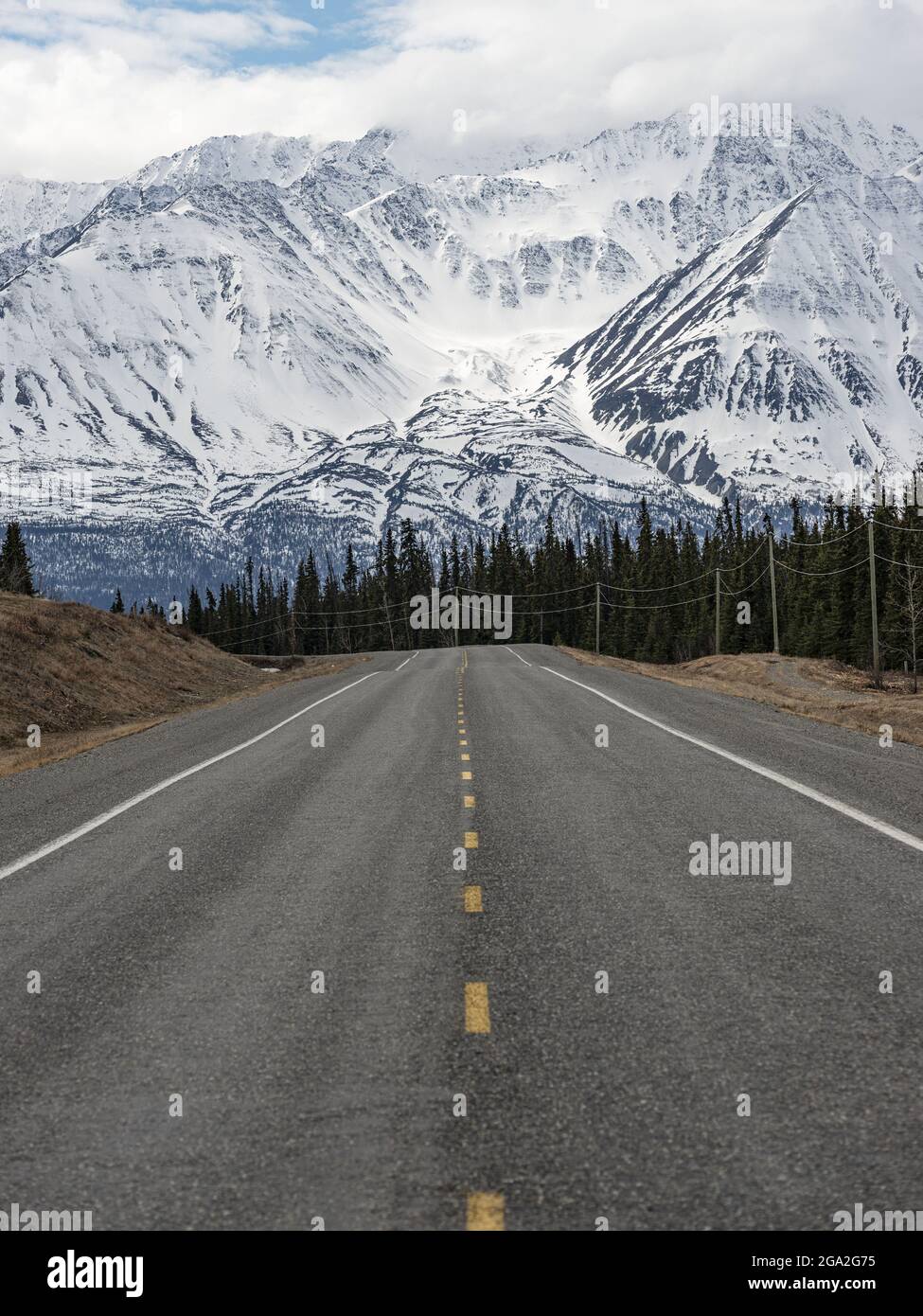 Alaska Highway just outside of the town of Haines Junction looking towards the mountains, situated in the Traditional Territory of the Champagne an... Stock Photo