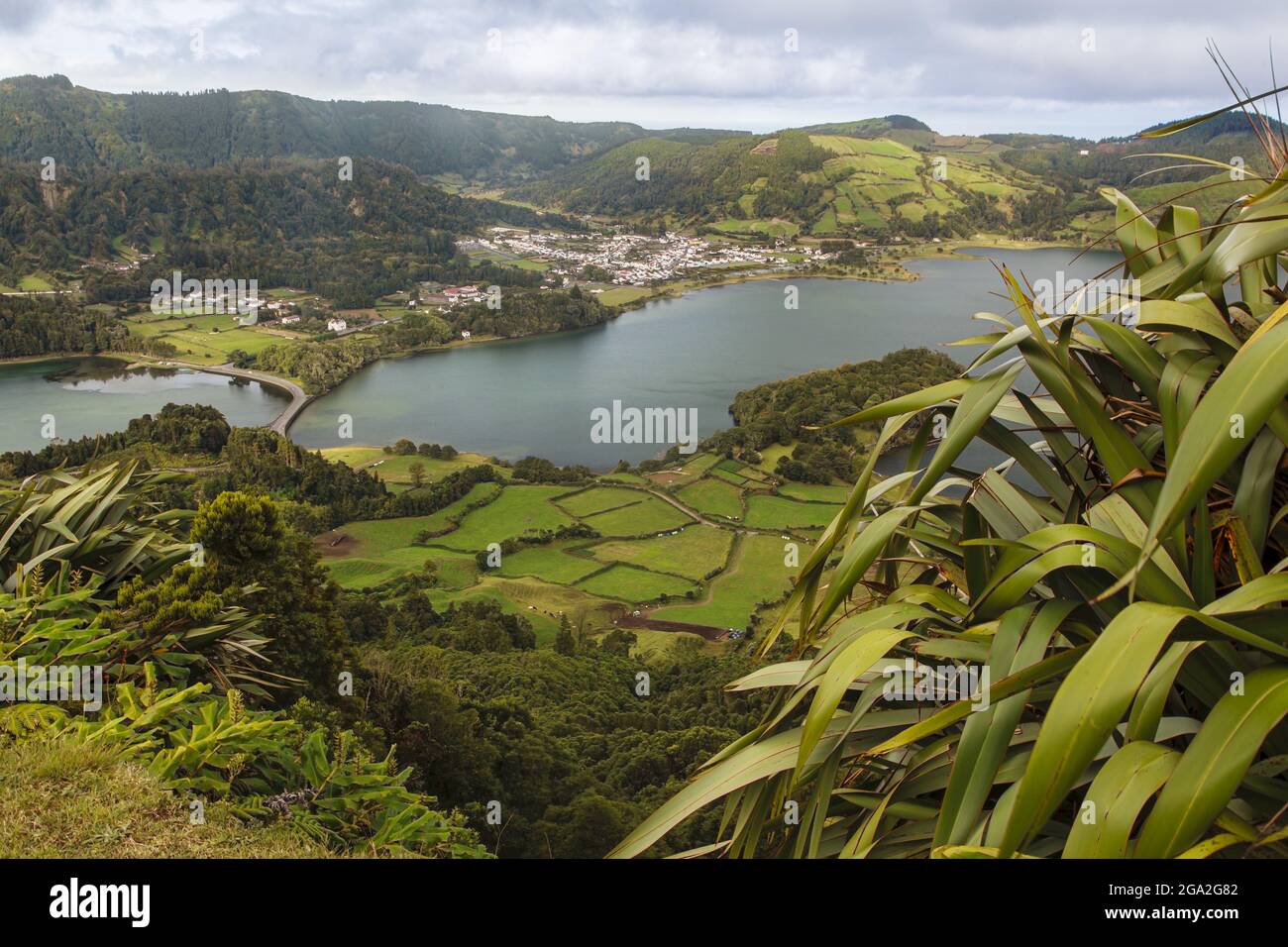 Scenic view of the lakes, farmland and lush vegetation of the Sete Cidades within the the massive volcanic crater that lies in the center of Ponta ... Stock Photo